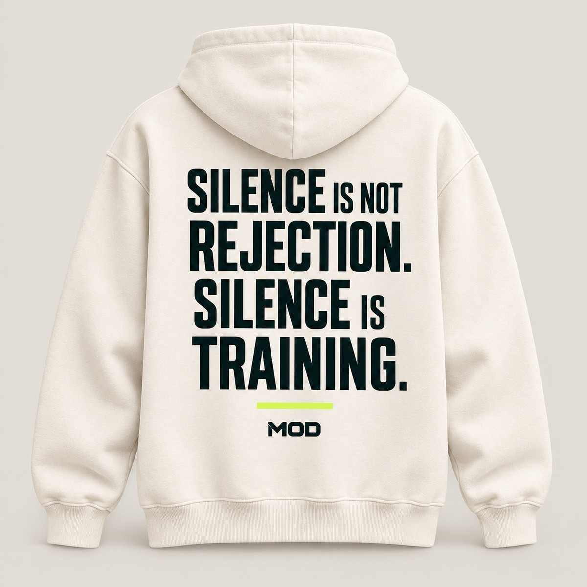 Concept ivory hoodie, back view, with “Silence Is Not Rejection. Silence Is Training.” lettering and MOD below.