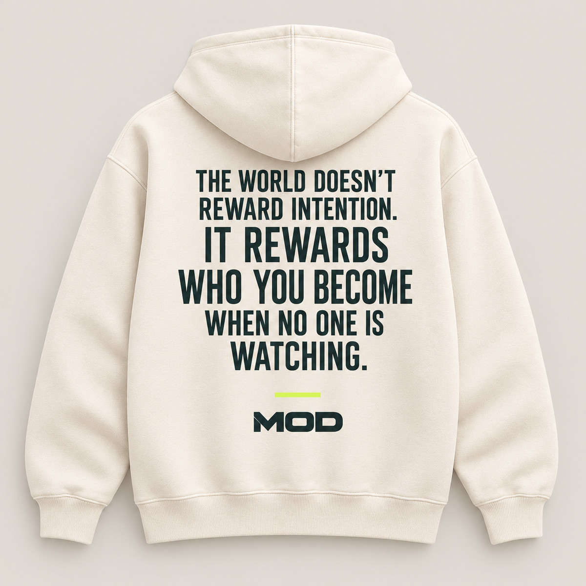 Concept ivory hoodie, back view, with “The World Doesn’t Reward Intention. It Rewards Who You Become When No One Is Watching.” lettering and MOD below.